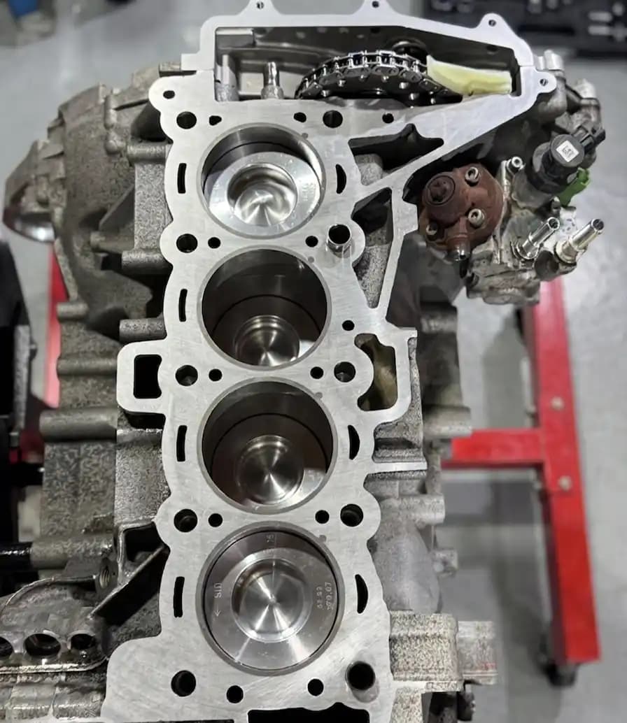 Close-up of exposed pistons and cylinder bores during head gasket work