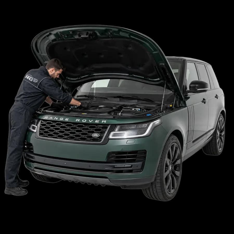 Mechanic inspecting a Range Rover engine bay with the bonnet open