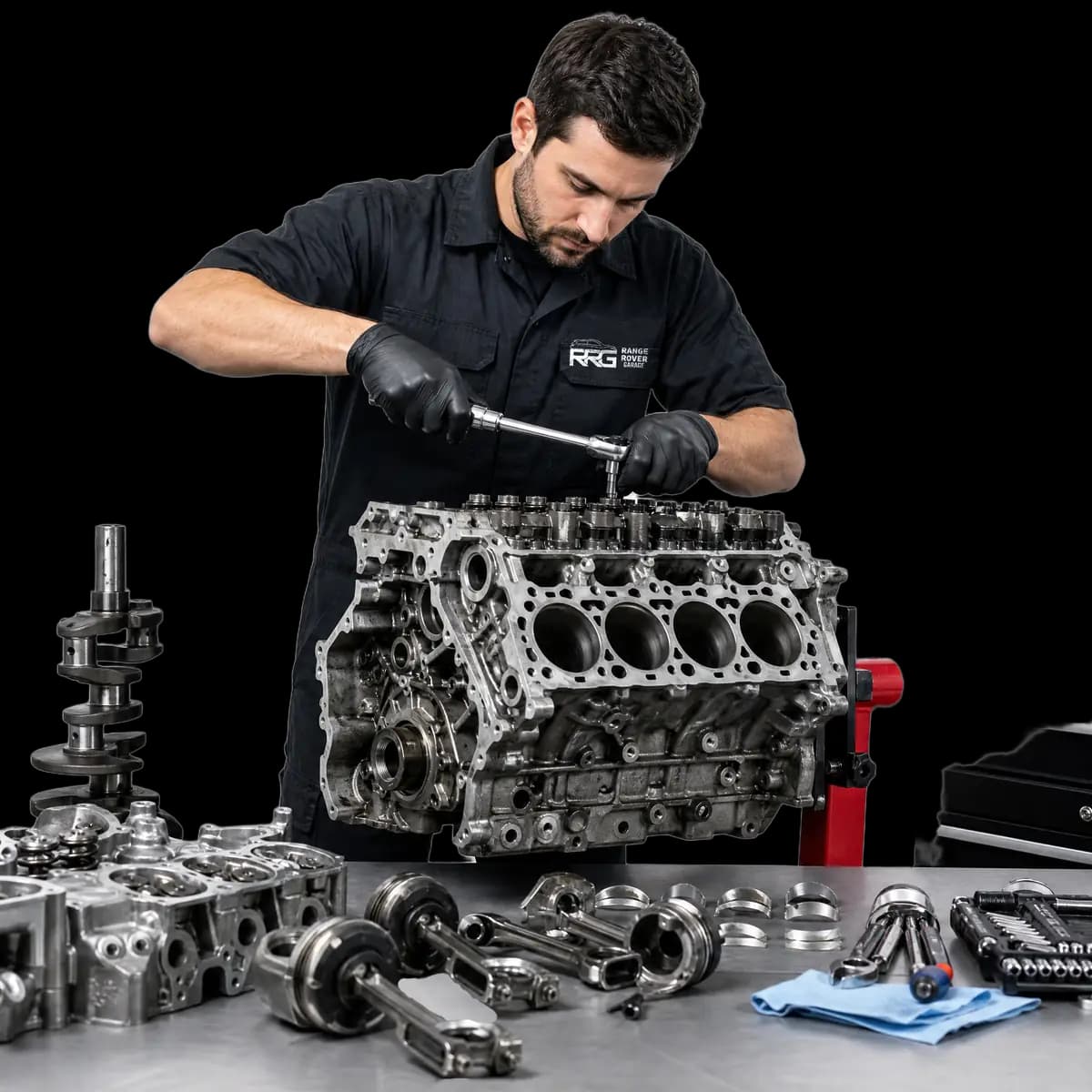 Mechanic working on an engine with a torque wrench beside dismantled engine parts