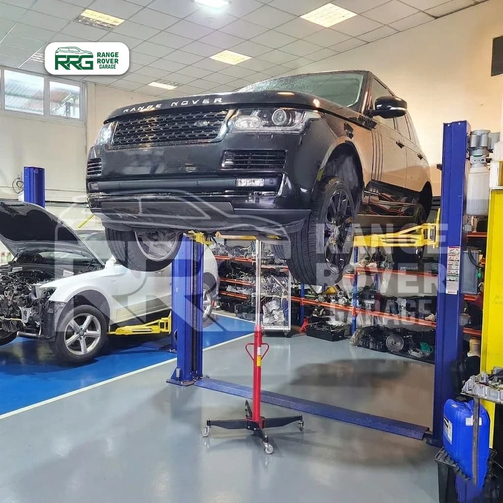 Range Rover raised on a workshop lift with an engine hoist in front