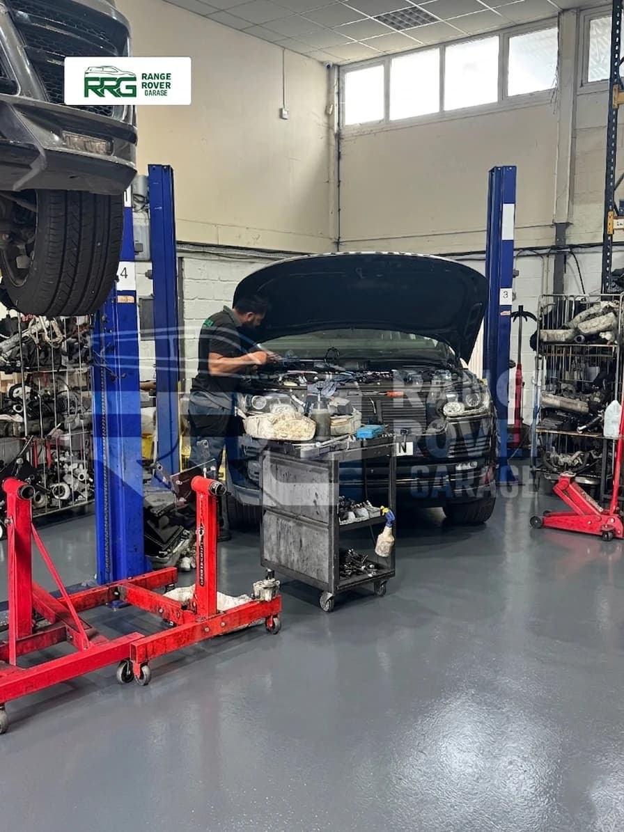 Range Rover with its bonnet open and engine removed in the workshop