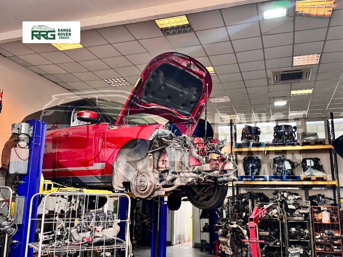Red Range Rover raised on a lift with its front wheel removed