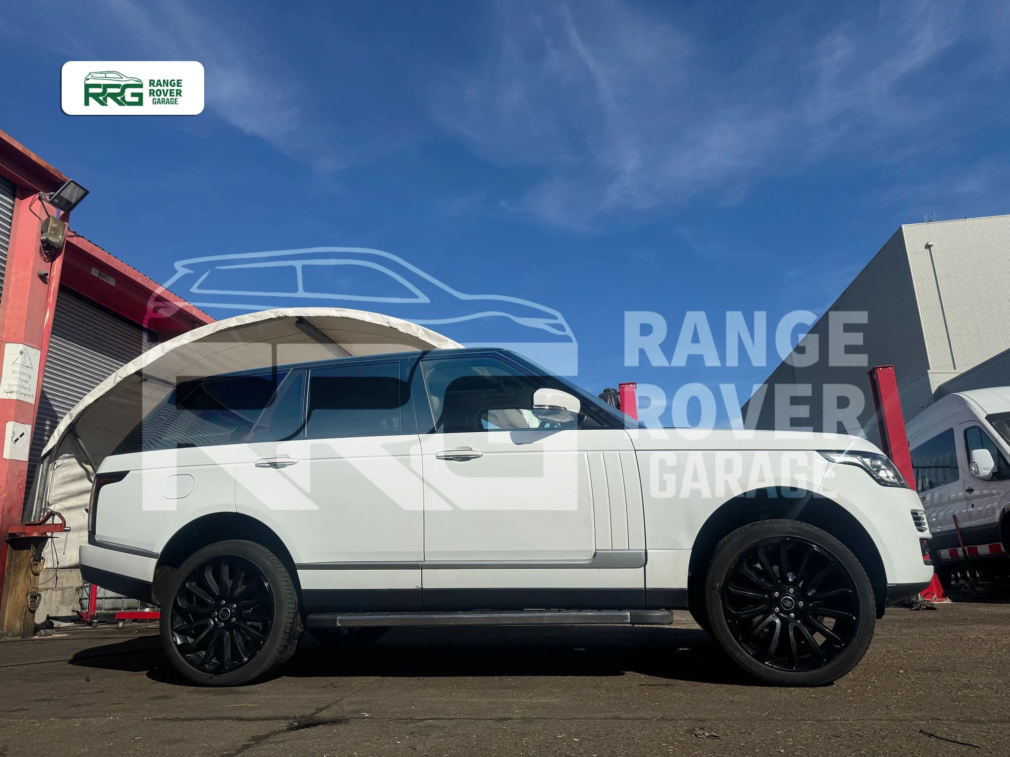 White Range Rover parked outside the garage