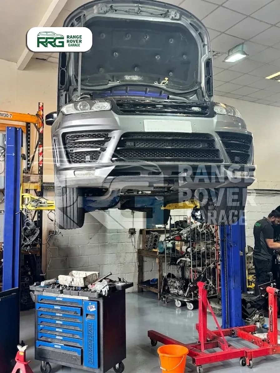 White Range Rover on a lift with its bonnet open and engine below