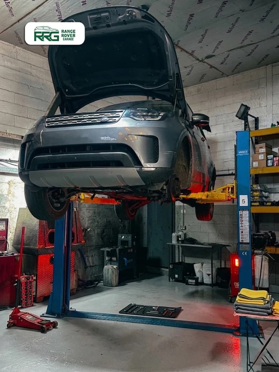 Range Rover on a lift with its bonnet open during engine work