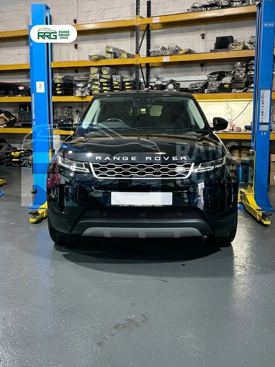 Black Range Rover positioned between workshop lift posts
